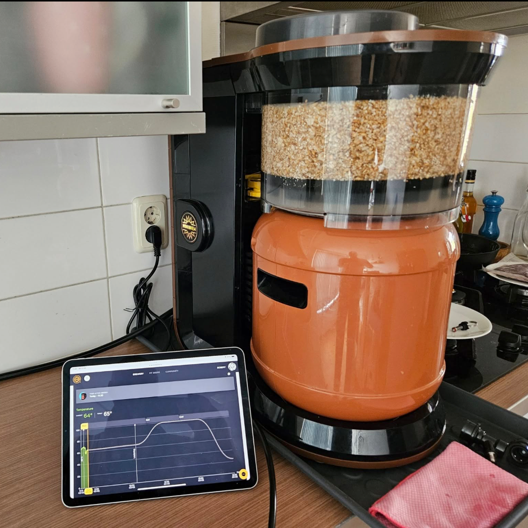 Cooper fermenting drink machine on a kitchen counter with a tablet displaying a graph.